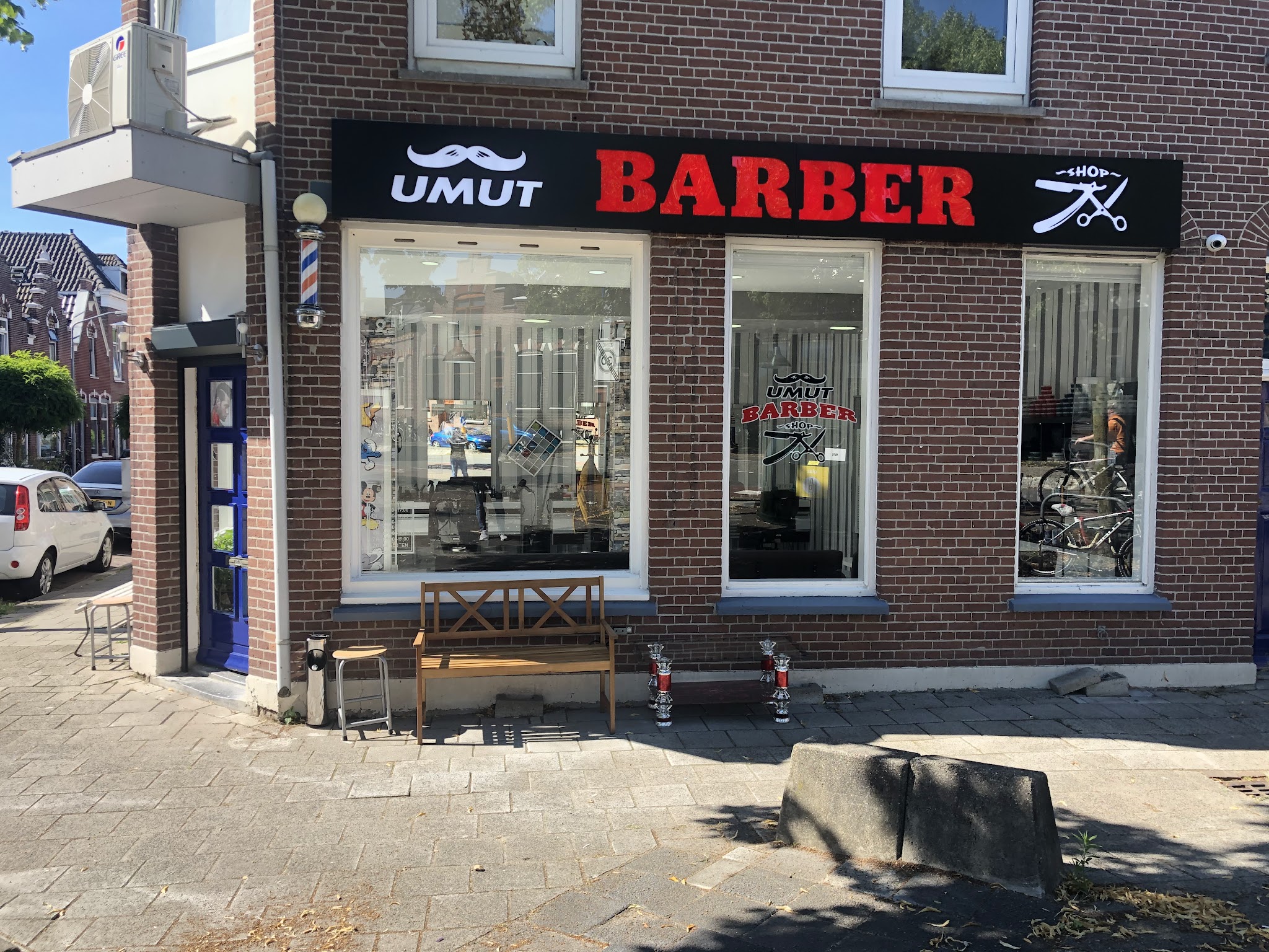 De hoekzaak van Umut Barbershop aan de Paul Krugerstraat, met het zwarte bord UMUT BARBER SHOP en een kapperspaal naast de deur